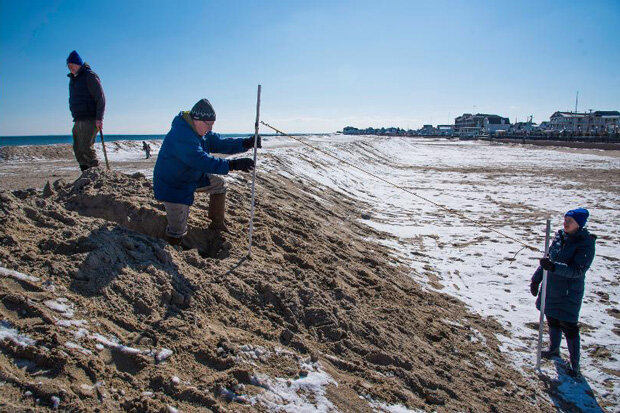 Volunteers hack a slot through a berm