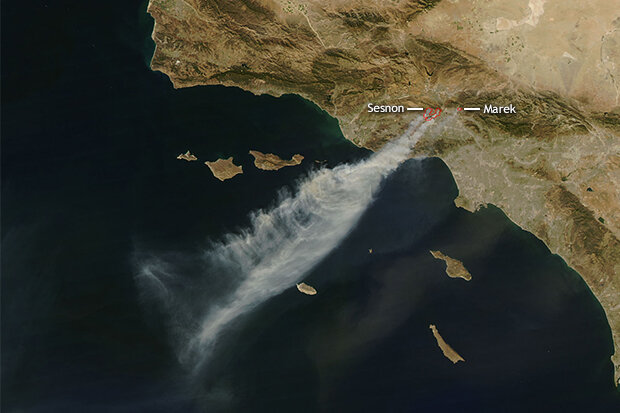satellite image of smoke streaming off land over water