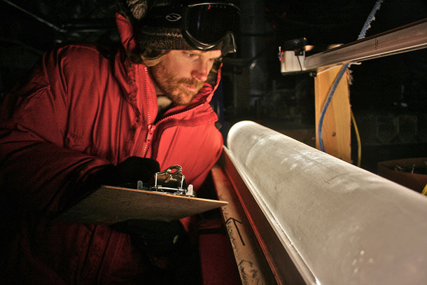 Photo of a scientist wtih a clipboard looking at an ice core