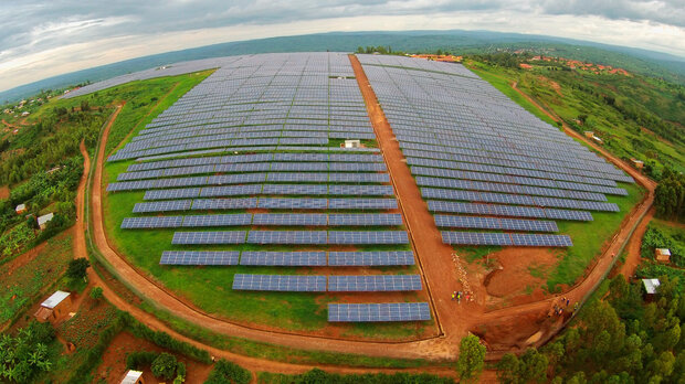 Aerial photo of solar array surrounded by trees and red dirt roads