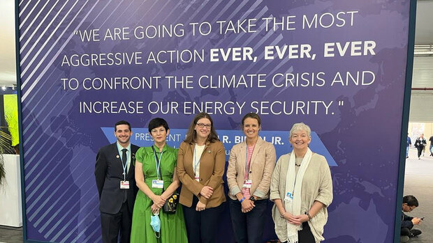 Kapnick and 4 colleagues in front of banner at COP-27