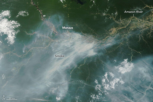 Satellite image of a pall of smoke over the green forests of the Amazon