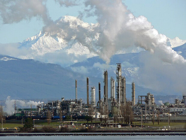 A mountain landscape behind a refinery