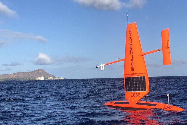 Photo of orange saildrone on ocean surface