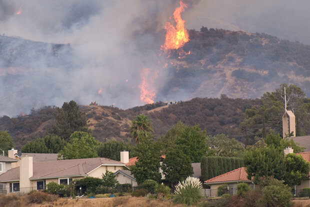Wildfire in hills behind homes