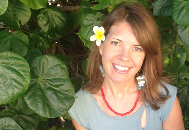 Profile picture of Jackie Kozak Thiel standing in front ofvine with large round leaves