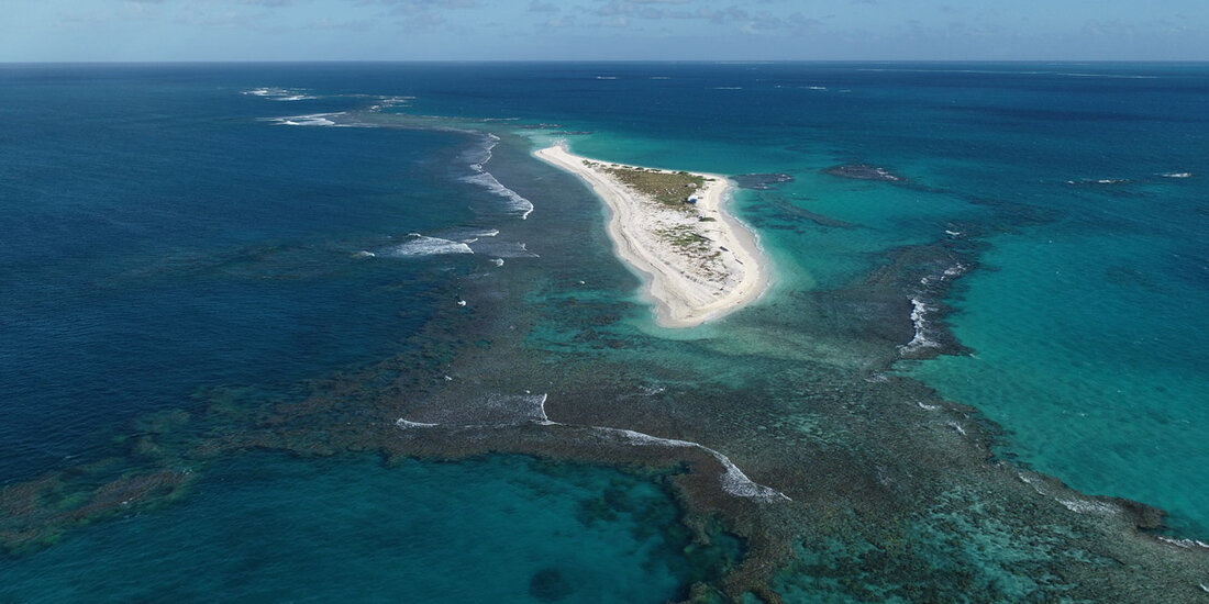 Aerial view of small, low-lying sandy island