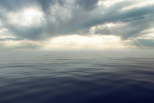 Smooth ocean surface and clouds